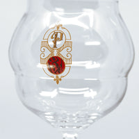 Verre à vin transparent avec logo doré et rouge Domaine Pilenium sur fond blanc